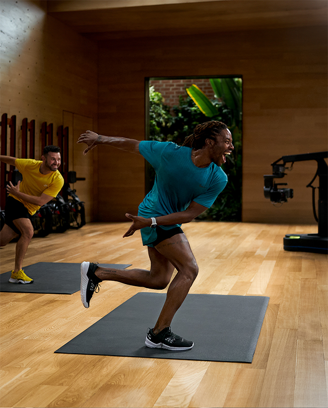 Apple Fitness+ eğitmenleri, video stüdyosunda bir antrenman seansı gerçekleştiriyor. 
