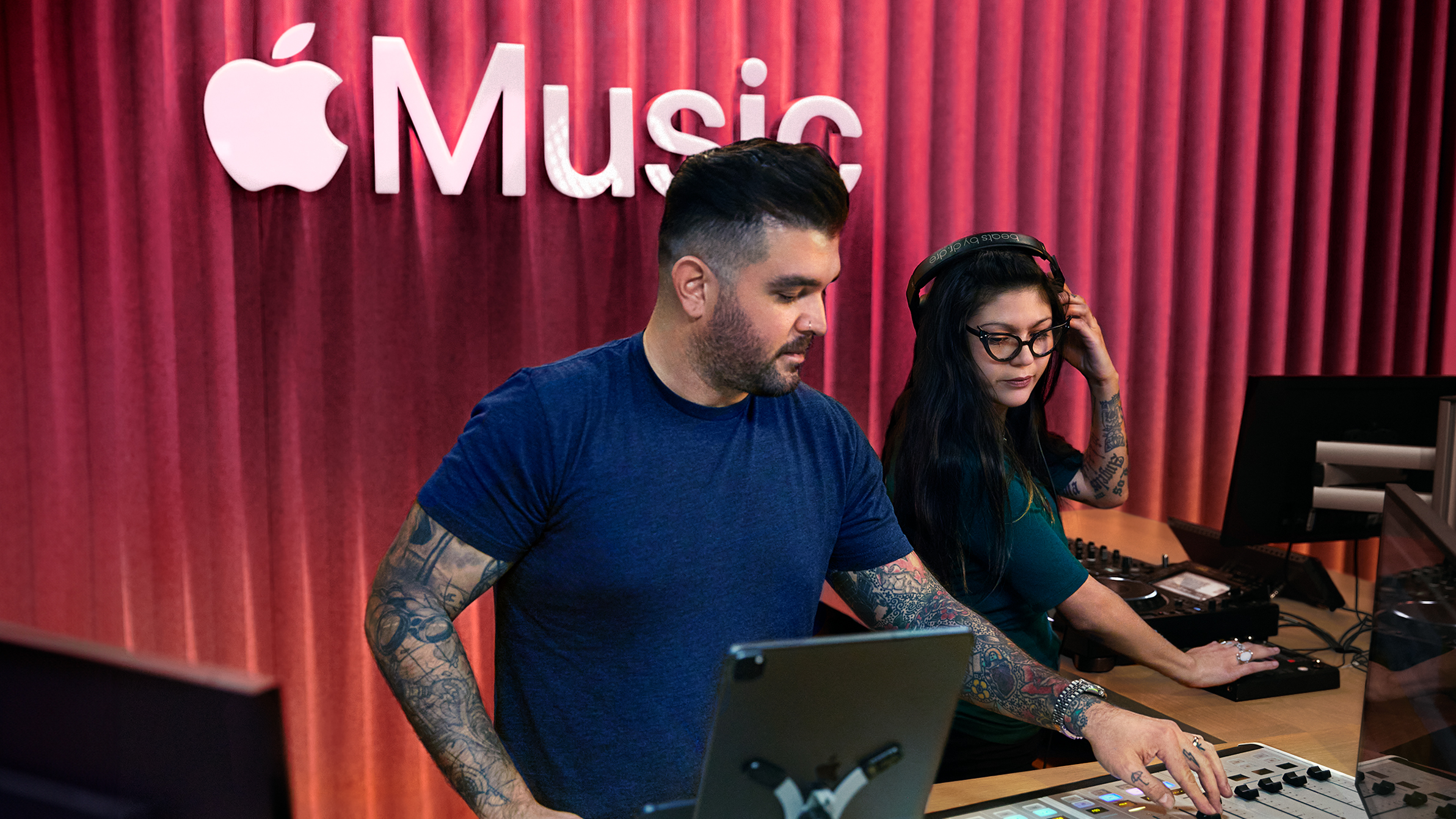 İki Apple çalışanı Apple Music stüdyosunda ses mikseri kullanıyor.