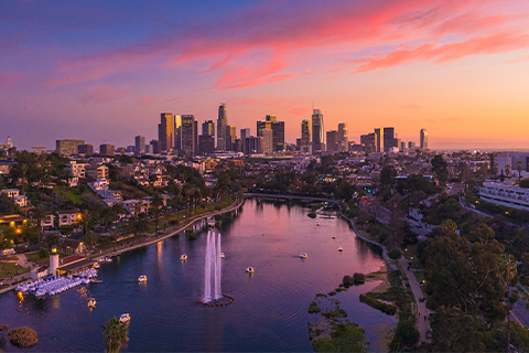 Ön planda bir park ve bir göl ile Los Angeles gökdelenlerine doğru uzanan manzaranın havadan görünümü.