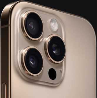 Primer plano de la parte posterior de un iPhone 16 Pro color titanio del desierto que muestra las cámaras y el botón lateral.